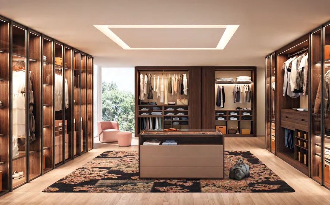 Walk-in closet with a central drawer island, hanging areas and glass-fronted storage