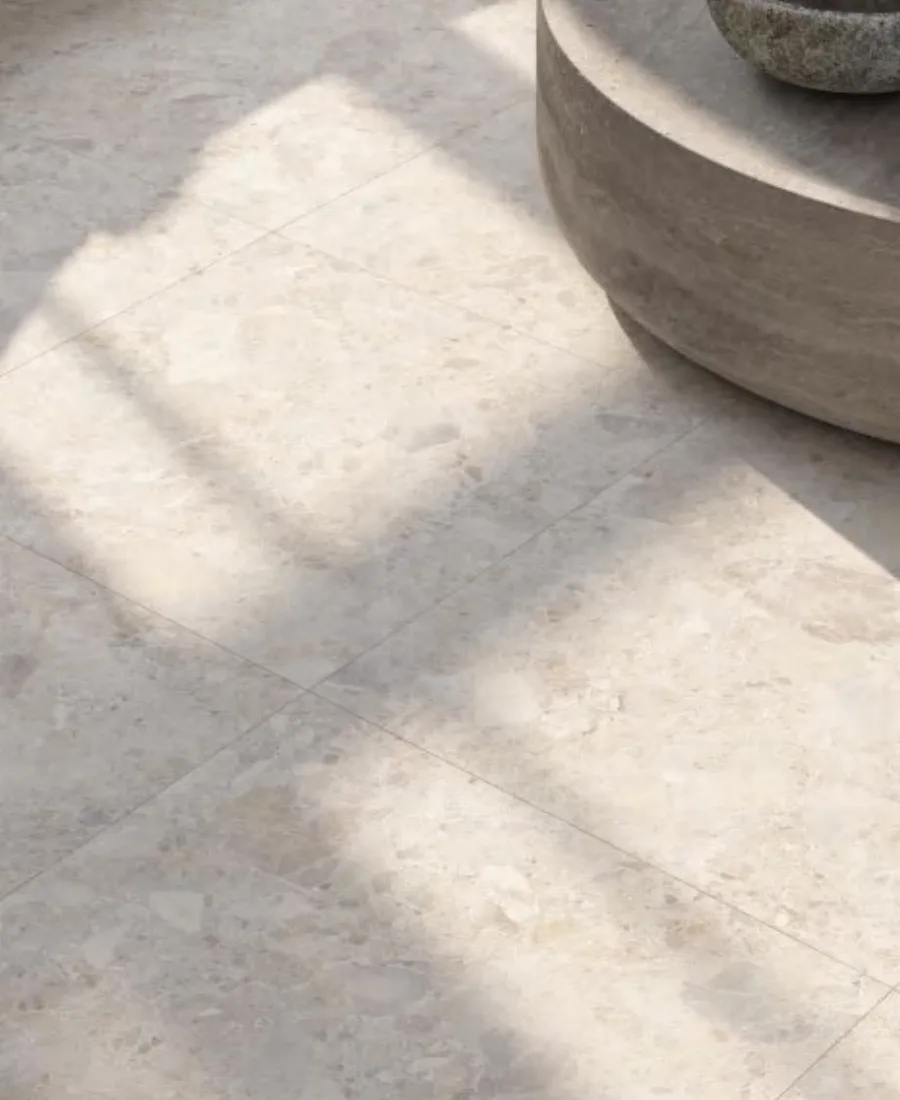 Close view of pale terrazzo-look floor tiles in directional sunlight