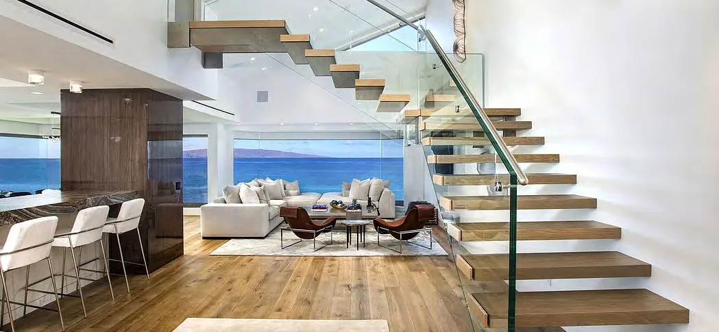 Turning open-riser stair with pale treads and glass balustrade