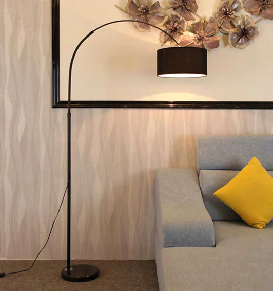 Arched floor lamp beside a sofa in a catalogue room