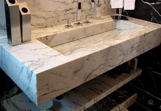 Veined stone vanity with a rectangular basin and deep front edge