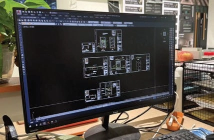 Computer monitor displaying multiple technical drawings in CAD software