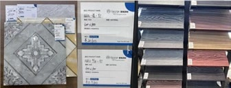 Labeled decorative surface samples beside sample information cards and racks of colored finish swatches