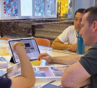People reviewing a tablet and printed interior references at a showroom table