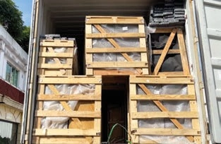 Wooden crates of different sizes stacked closely inside an open shipping container