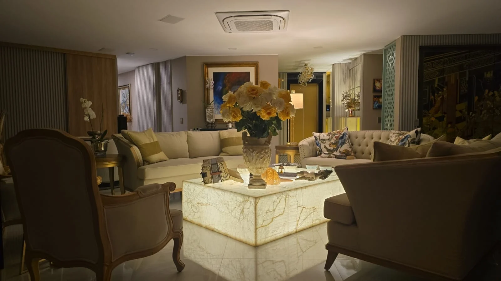 Colombia interior with upholstered seating, a stone-look coffee table, wall panels and decorative lighting